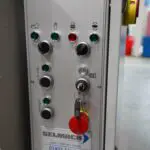 Industrial control panel for a Selmach machine featuring various buttons, indicator lights, a keyed ignition, and a red emergency stop button