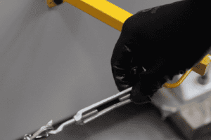 Close up of a hand turning the wire tension on a rolling machine