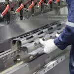 Image of gloved hands working at a pressbrake