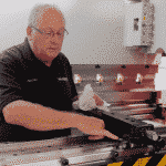 Image of a Selmach engineer inside the press brake conducting general maintenance on the backgauge