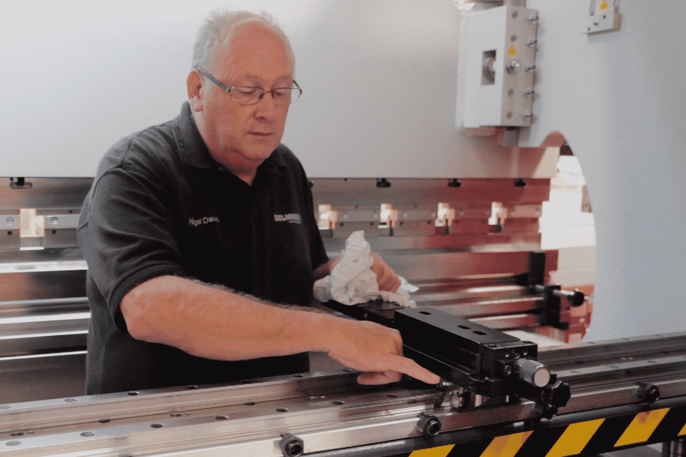 Image of a Selmach engineer inside the press brake conducting general maintenance on the backgauge
