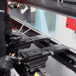 View of operator adjusting a press brake backgauge inside of the machine