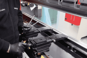 View of operator adjusting a press brake backgauge inside of the machine