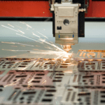 Close up image of the cutting head cutting metal on a Fibre Laser