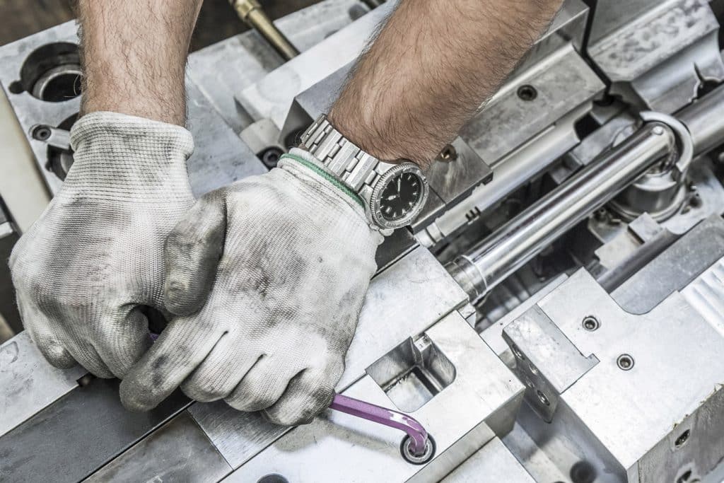 Image of hands fixing a machine