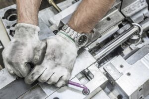 Image of hands fixing a machine