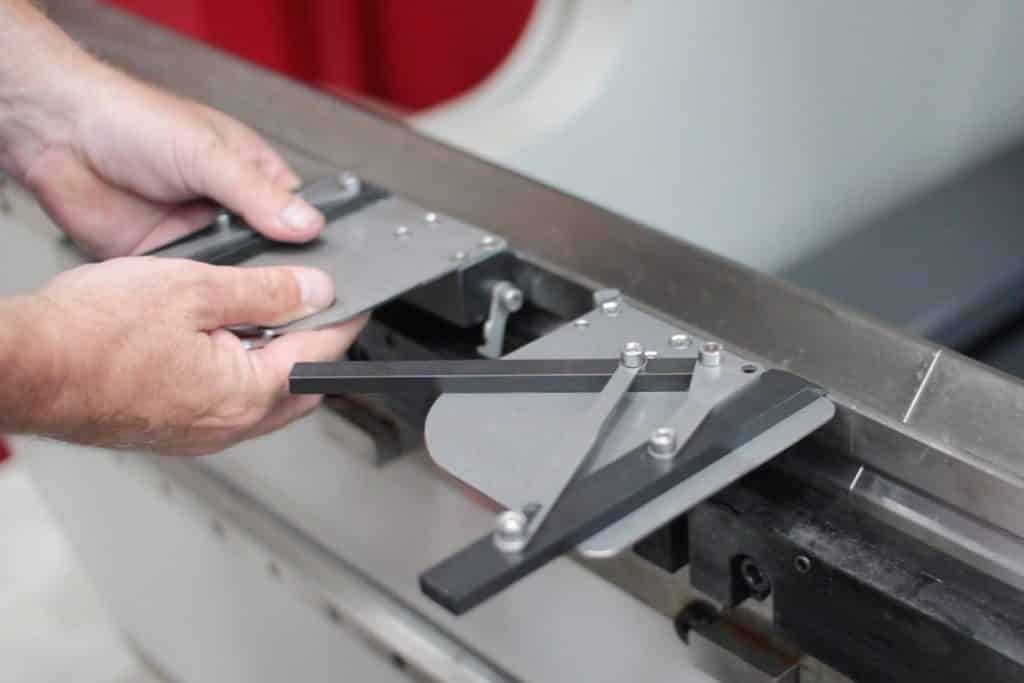 Image of hands attaching the squaring arm onto a press brake